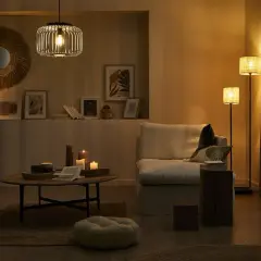 Przytulny salon z dwiema lampami, które tworzą ciepłą atmosferę. Na stoliku kawowym palą się świece.