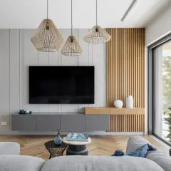 Nowoczesny salon z szarymi meblami i drewnianymi panelami. Trzy wiszące lampy tworzą przytulną atmosferę, idealną do relaksu. Zastanawiasz się, ile lumenów do salonu?