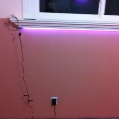 Różowe ściany, okno, fioletowe światło LED. Jak ukryć zasilacz LED w ścianie? Wtyczka w gniazdku.
