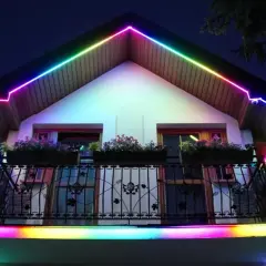 Kolorowy led w podbitce domu tworzy tęczową iluminację dachu i balkonu, nadając nocnej fasadzie magiczny wygląd.