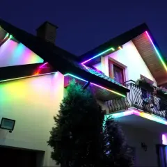 Kolorowe taśmy LED ozdabiają dach i balkon domu, tworząc magiczną atmosferę. Idealne, jakie ledy do pokoju, by rozświetlić noc.