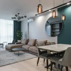 Nowoczesna lampa do salonu, wisząca nad stołem, tworzy przytulną atmosferę.