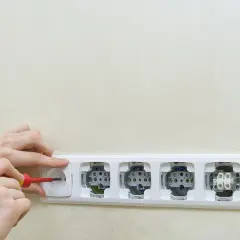 Ręce montują włącznik światła do gniazdka. Schemat jak podłączyć włącznik światła z gniazdka.