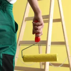 Malowanie ścian to łatwiejsze z tym wałkiem. W tle drabina i żółta ściana.