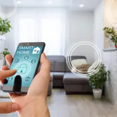 Smart home od czego zacząć? Telefon z aplikacją sterującą domem w nowoczesnym salonie.