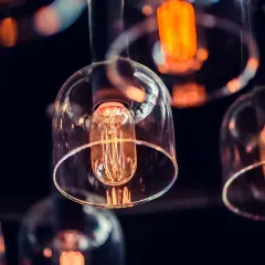 Szklane klosze okrywają żarówki Edisona, tworząc ciepłe, pomarańczowe światło. Ich styl retro, z widocznym parametrem ra, nadaje wnętrzu unikalny charakter.