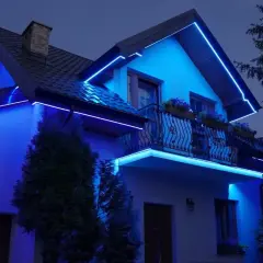 Niebieskie oświetlenie wnęki w ścianie domu podkreśla architekturę, tworząc magiczną atmosferę.