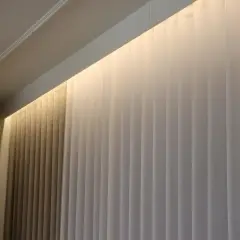 Eleganckie zasłony z podświetleniem ściany od góry tworzą przytulną atmosferę.