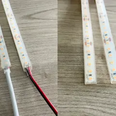 Dwie taśmy LED z widocznymi połączeniami i przewodami, jedna z białym kablem, druga z czerwonym i czarnym.