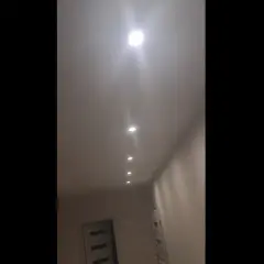 W korytarzu widać rząd wbudowanych w sufit lamp, które tworzą migające światło.