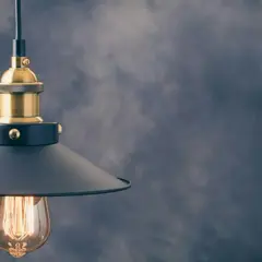 Stylowa lampa wisząca z czarnym kloszem i złotymi elementami. To modne oświetlenie idealnie wpasuje się w industrialne wnętrza.