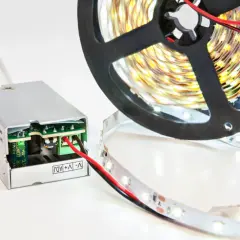 Zasilacz do taśmy LED, który może okazać się za mocny. Rolka taśmy LED i podłączony zasilacz.