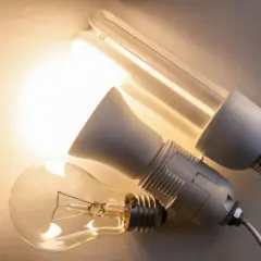 Trzy żarówki: tradycyjna, energooszczędna i adapter. Różne oznaczenia żarówek led i ich poprzedniczek.