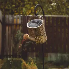 Ozdobna konewka z panelem solarnym, wisząca na haku. Czy lampa solarna ładuje się w cieniu?