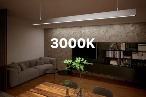Ciepła barwa światła 3000K idealnie podkreśla przytulną atmosferę salonu z szarą kanapą i drewnianym stołem.