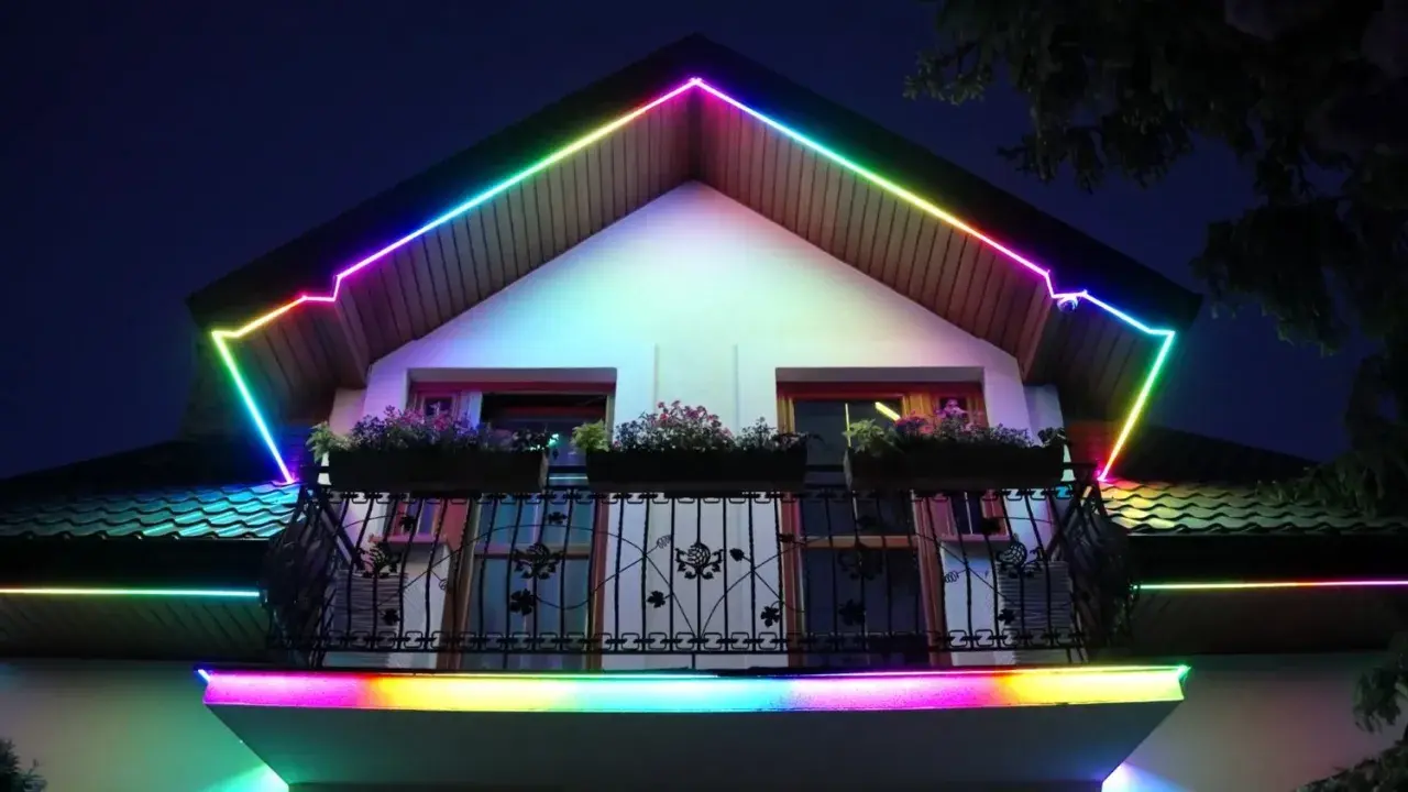 Kolorowy led w podbitce domu tworzy tęczową iluminację dachu i balkonu, nadając nocnej fasadzie magiczny wygląd.
