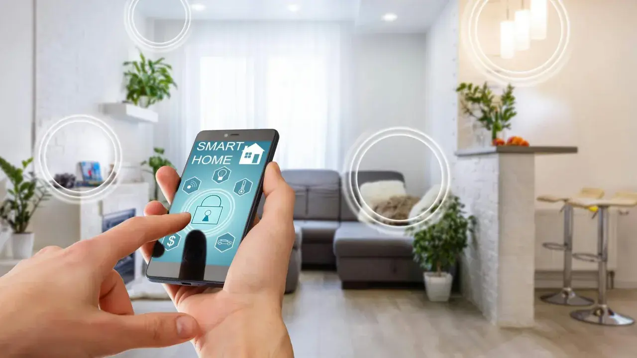 Smart home od czego zacząć? Telefon z aplikacją sterującą domem w nowoczesnym salonie.