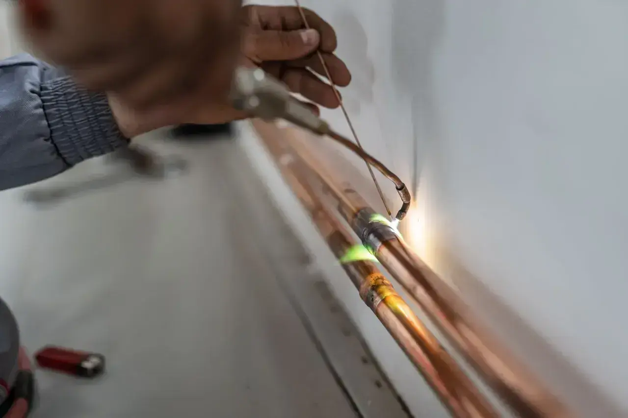 Precyzyjne lutowanie przewodów elektrycznych, gdzie płomień palnika topi spoiwo, tworząc trwałe połączenie.