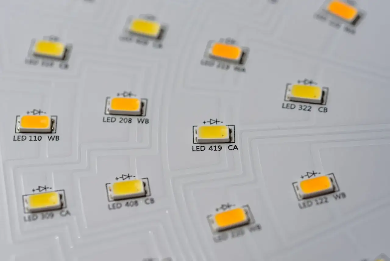 Na białej płytce widać rzędy małych diod LED. Każda dioda ma oznaczenie, np. LED 110 WB. To pokazuje, że smd co to znaczy, to małe komponenty elektroniczne.