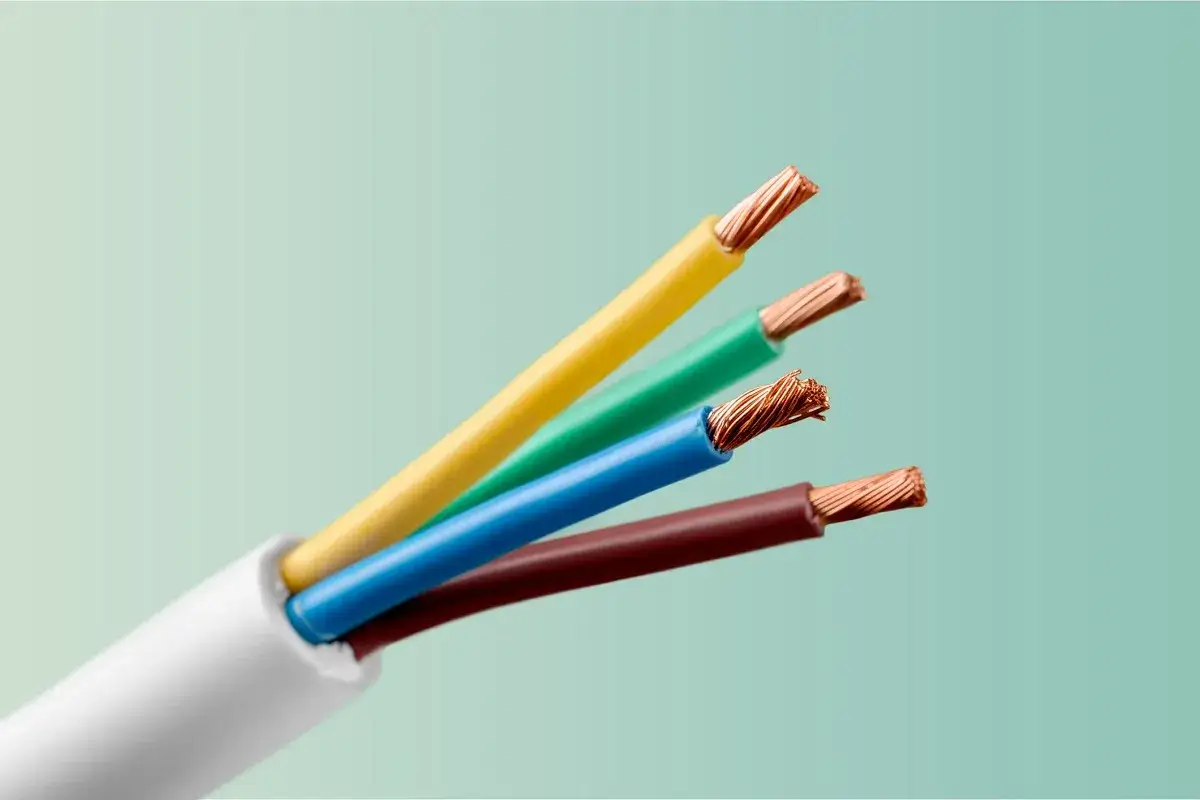Cztery kolorowe przewody elektryczne: żółty, zielony, niebieski i brązowy, wystające z białej izolacji.