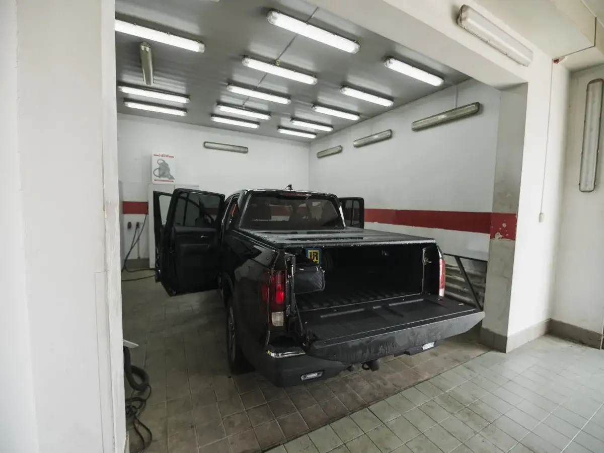 Jasne, oto opis alternatywny:

Czarne auto z otwartymi drzwiami i klapą bagażnika w garażu. Sufit oświetlają liczne jarzeniówki, idealne, gdy zastanawiasz się, jakie lampy do garażu wybrać.