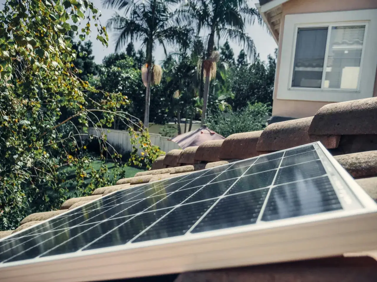Panel solarny na dachu, częściowo w cieniu drzew. Czy lampa solarna ładuje się w cieniu?