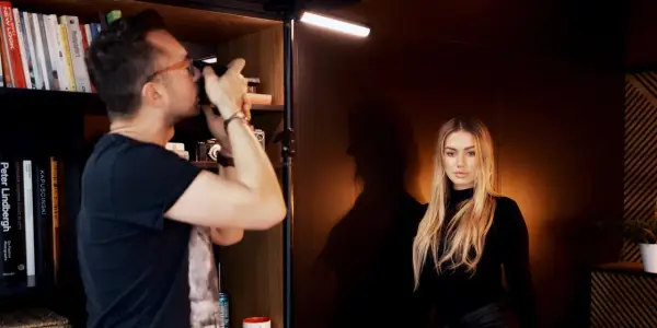 Fotograf robi zdjęcie modelce, tworząc idealne podświetlenie obrazu.