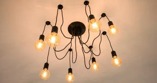 Nowoczesna lampa sufitowa z wieloma żarówkami. Dowiedz się, jak przesunąć lampę sufitową bez kucia, wykorzystując jej elastyczną konstrukcję.